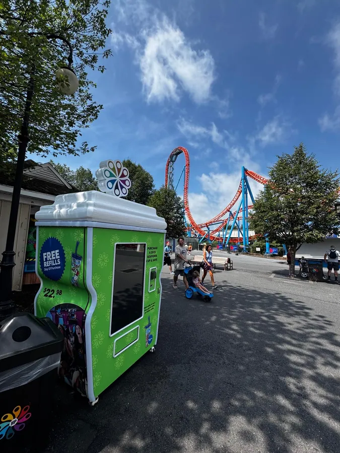 A custom Sweet Robo souvenir-cup machine deployed at Hersheypark, with roller coasters behind